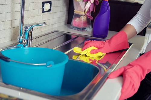 Cleaner tidying a kitchen in a TW1 residential property